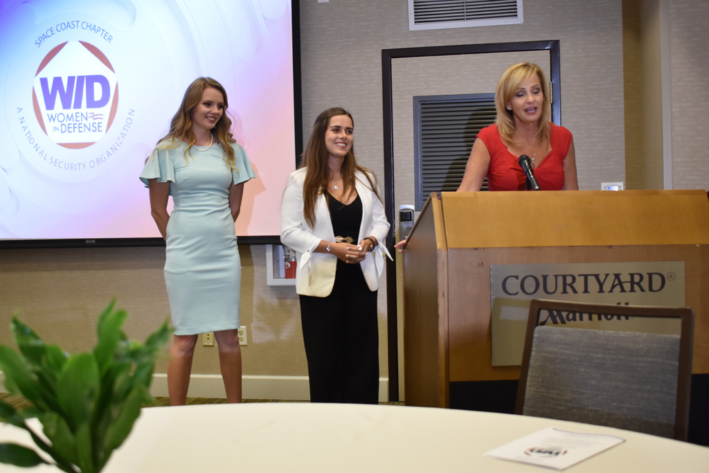 WIDSC awards presentation. Three women are standing at the podium getting ready to speak.