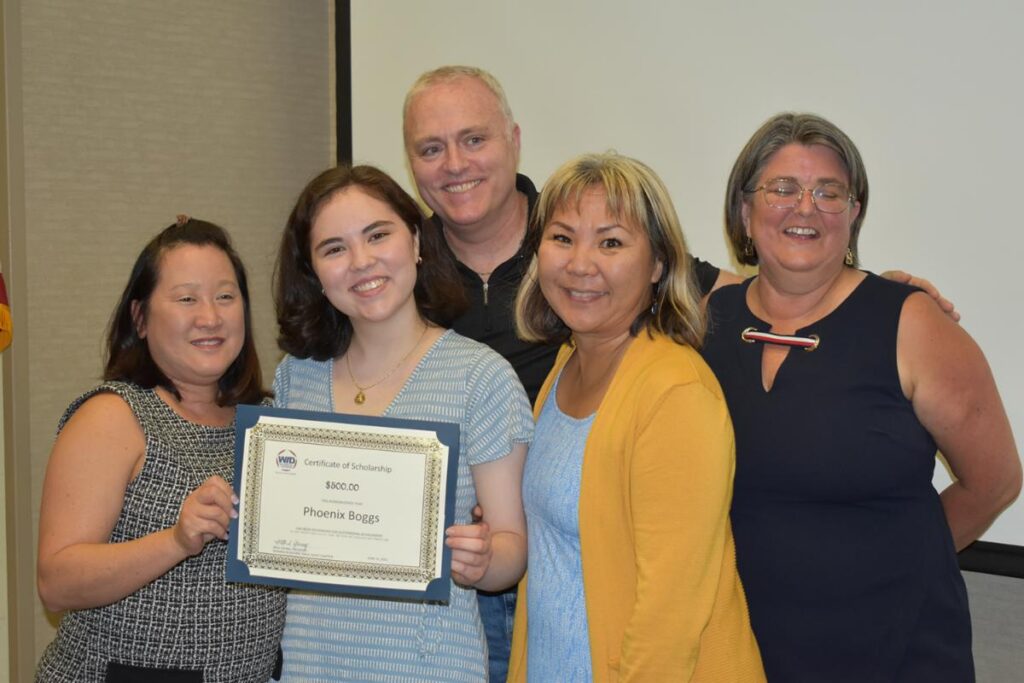 Five people stand with the STEM Scholarships Education Mentor and Business of the Year recipient for a picture.