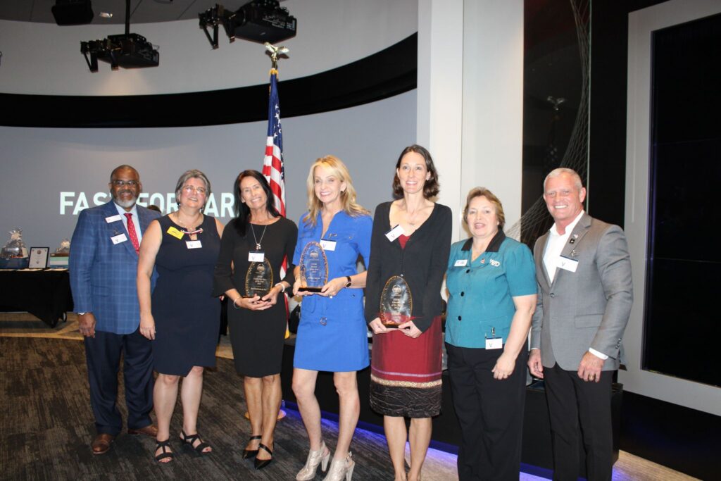 Seven WID winners are standing together for a group photo.
