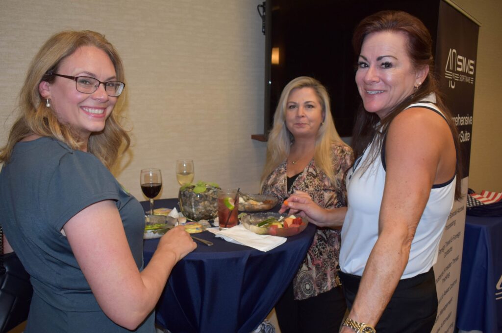 Three woman standing at a table.