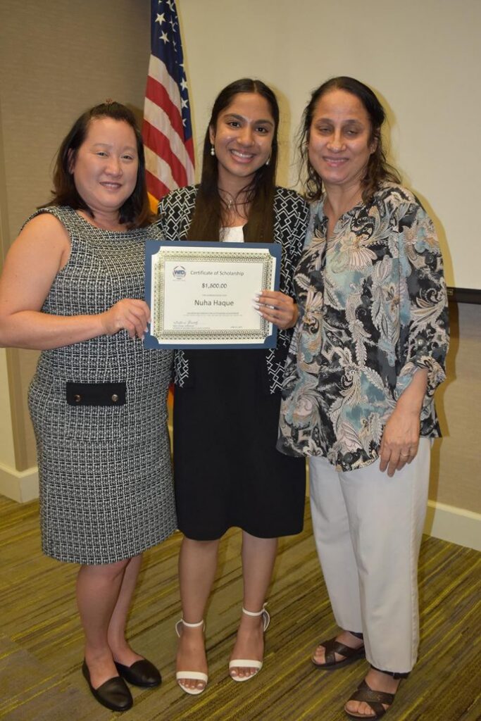 Nuha Haque poses for a photo holding her scholarship award